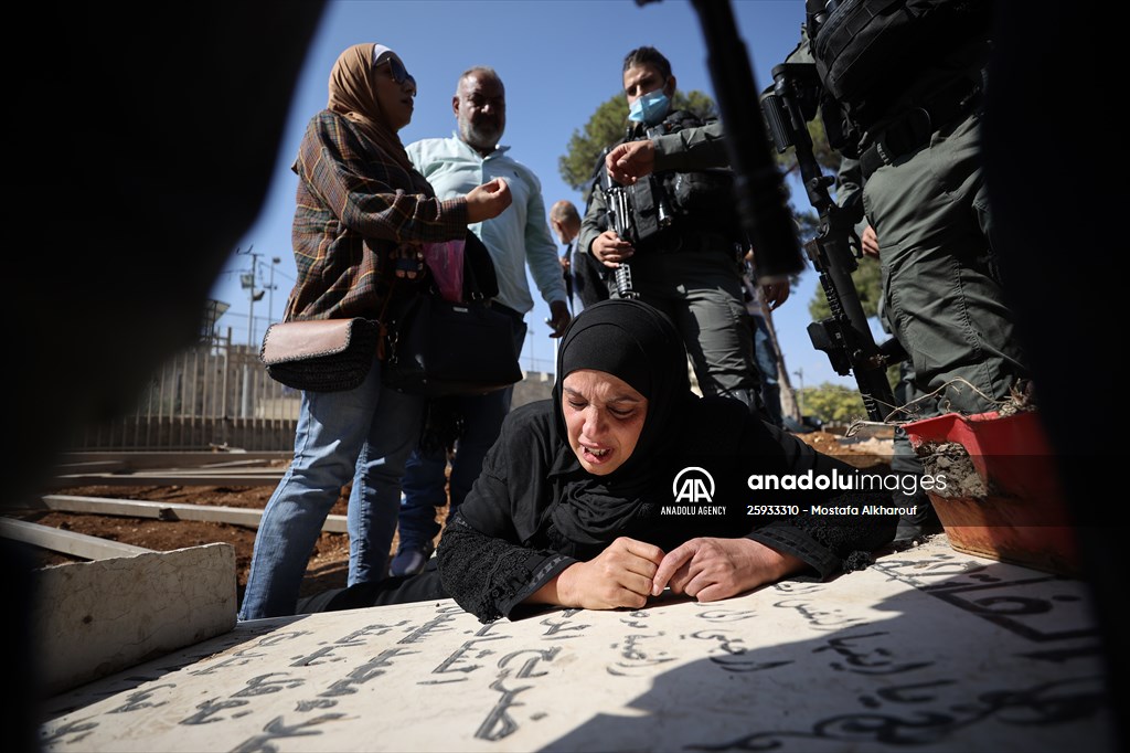 Palestinian mother reacts on her son's grave to Israel's works to turn part of cemetery into a park