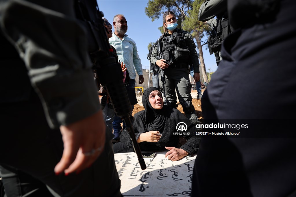 Palestinian mother reacts on her son's grave to Israel's works to turn part of cemetery into a park