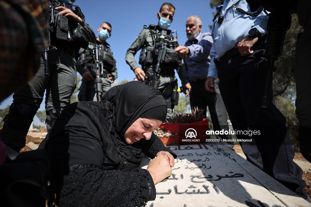 Palestinian mother reacts on her son's grave to Israel's works to turn part of cemetery into a park