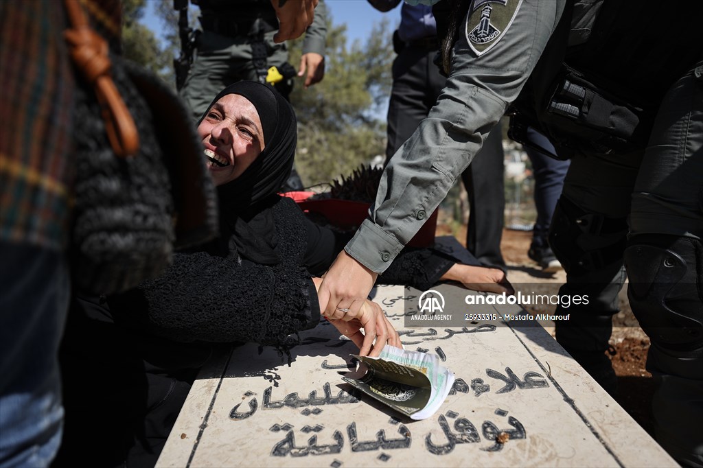 Palestinian mother reacts on her son's grave to Israel's works to turn part of cemetery into a park