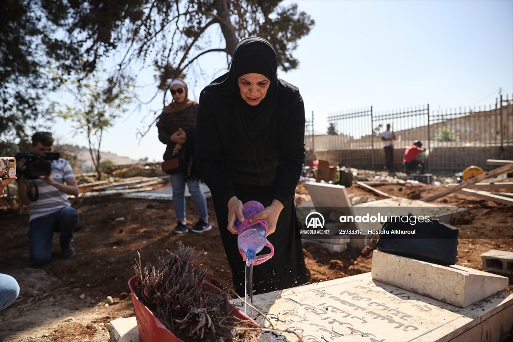 Palestinian mother reacts on her son's grave to Israel's works to turn part of cemetery into a park