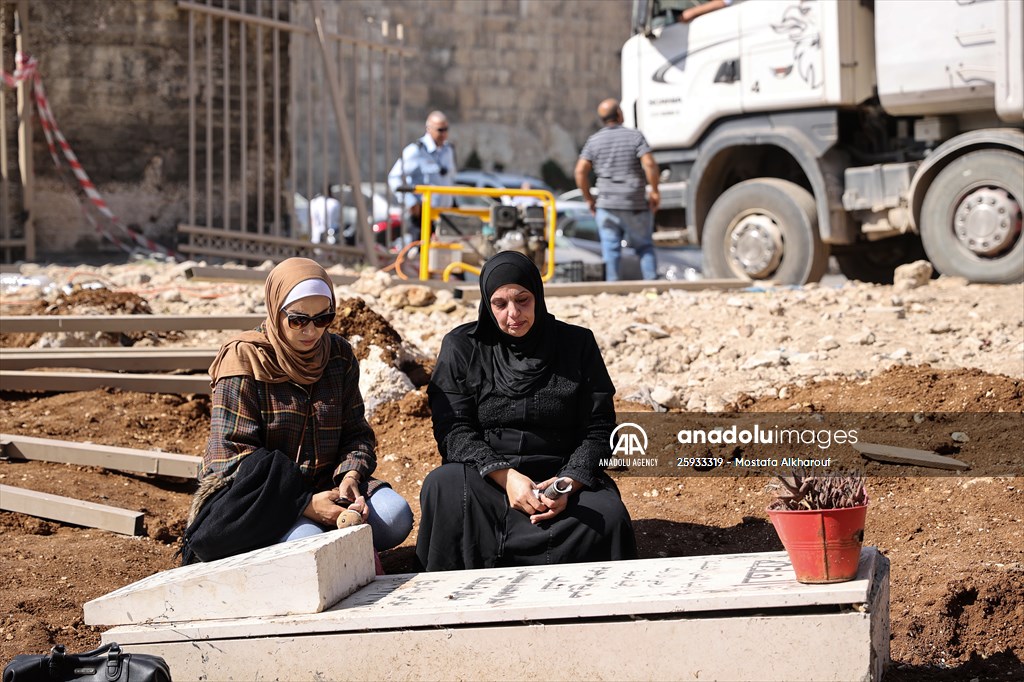 Palestinian mother reacts on her son's grave to Israel's works to turn part of cemetery into a park