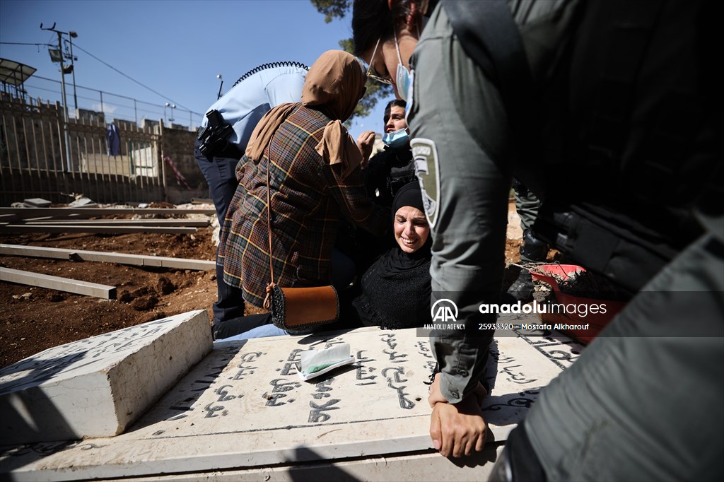 Palestinian mother reacts on her son's grave to Israel's works to turn part of cemetery into a park