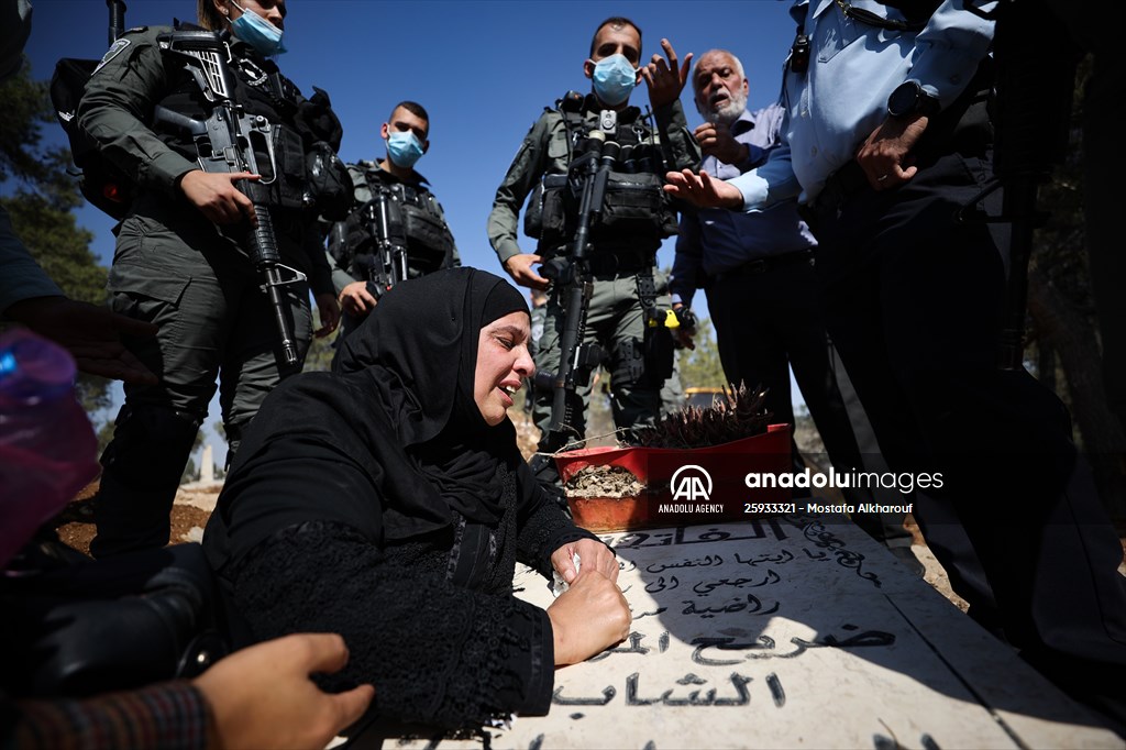 Palestinian mother reacts on her son's grave to Israel's works to turn part of cemetery into a park