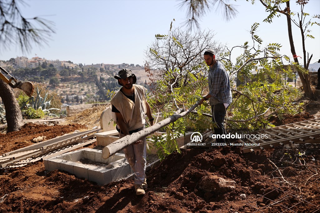 Palestinian mother reacts on her son's grave to Israel's works to turn part of cemetery into a park