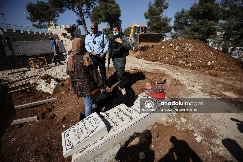 Palestinian mother reacts on her son's grave to Israel's works to turn part of cemetery into a park