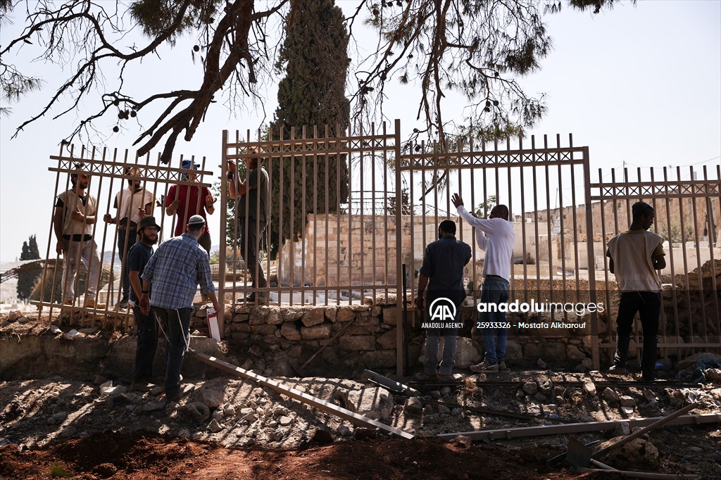 Palestinian mother reacts on her son's grave to Israel's works to turn part of cemetery into a park