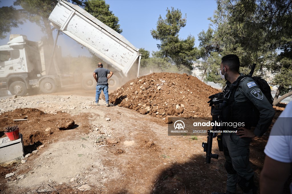 Palestinian mother reacts on her son's grave to Israel's works to turn part of cemetery into a park