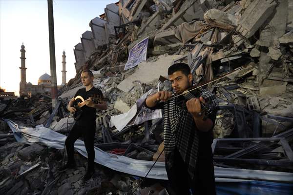 Palestinian musicians in Gaza perform concert in front of debris of buildings