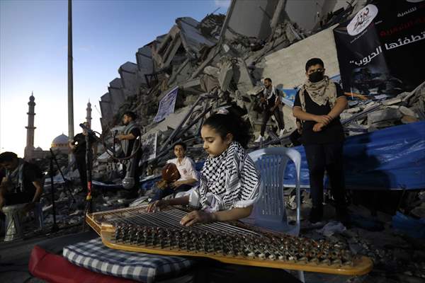 Palestinian musicians in Gaza perform concert in front of debris of buildings