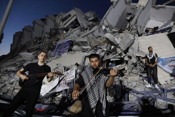 Palestinian musicians in Gaza perform concert in front of debris of buildings