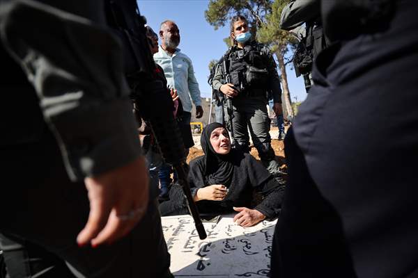 Palestinian mother reacts on her son's grave to Israel's works to turn part of cemetery into a park