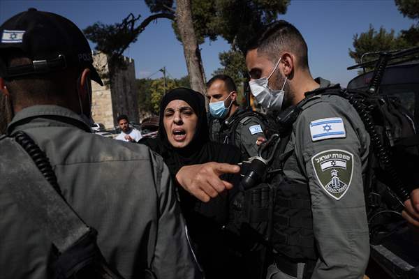 Palestinian mother reacts on her son's grave to Israel's works to turn part of cemetery into a park