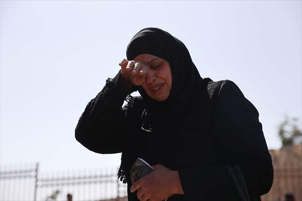 Palestinian mother reacts on her son's grave to Israel's works to turn part of cemetery into a park