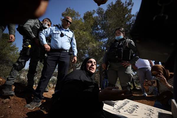 Palestinian mother reacts on her son's grave to Israel's works to turn part of cemetery into a park