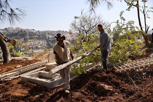 Palestinian mother reacts on her son's grave to Israel's works to turn part of cemetery into a park