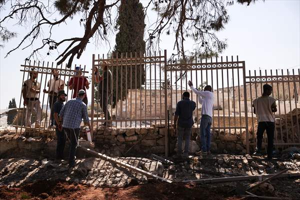 Palestinian mother reacts on her son's grave to Israel's works to turn part of cemetery into a park