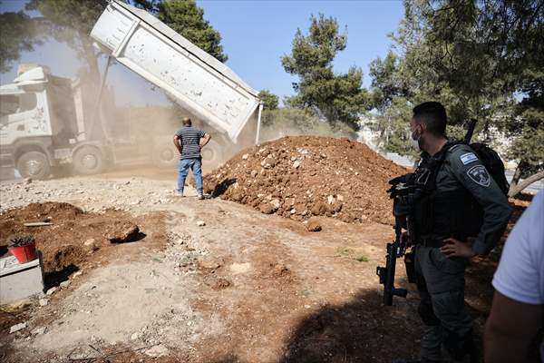 Palestinian mother reacts on her son's grave to Israel's works to turn part of cemetery into a park