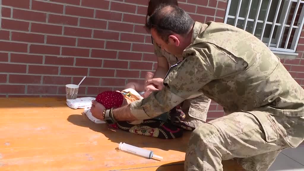 Turkish soldiers look after Afghan baby thrown over razor wire by desperate mother at Kabul airport