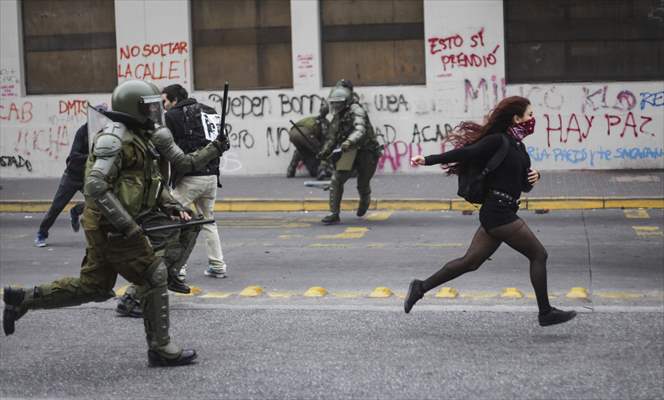 Protester running away from the police in Chile’s Concepcion